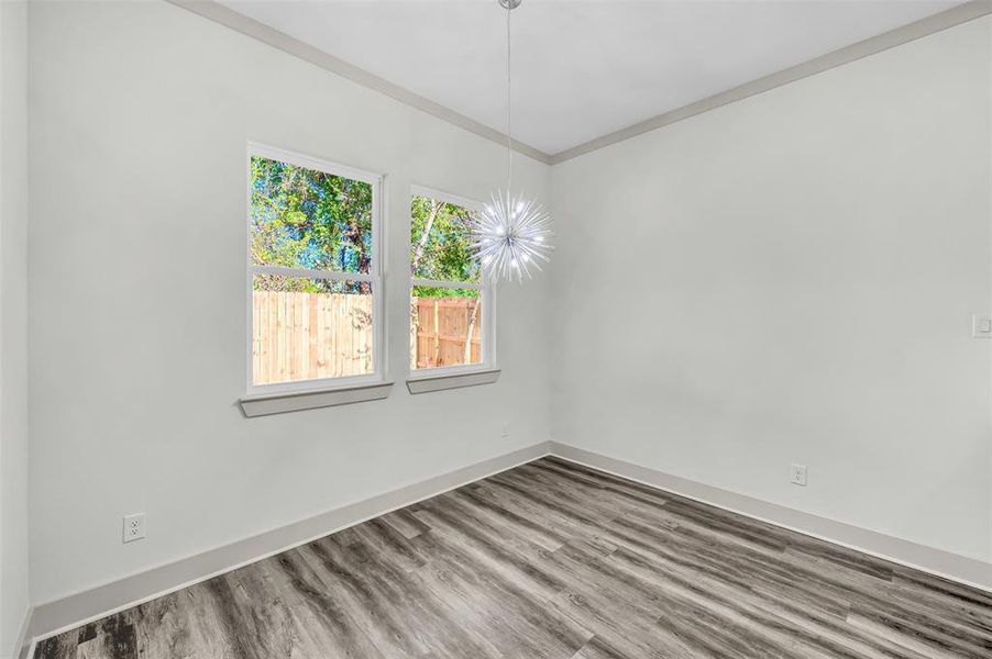 Unfurnished room with wood finished floors and crown molding