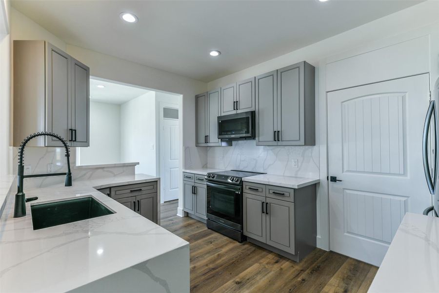 The kitchen features courts countertops, refrigerator, dishwasher, stove and microwave The kitchen features courts countertops, refrigerator, dishwasher, stove and microwave
