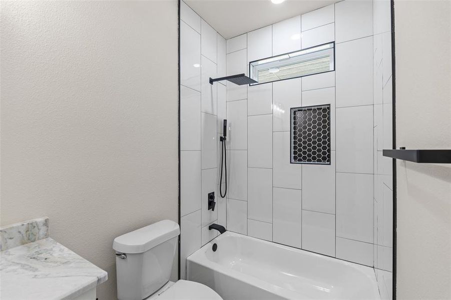 Full bathroom with vanity, toilet, and tiled shower / bath