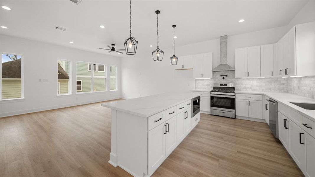 This photo highlights the open space - also featuring the flex space adjacant the kitchen. A great space for a dining room, home office, or bonus living space.