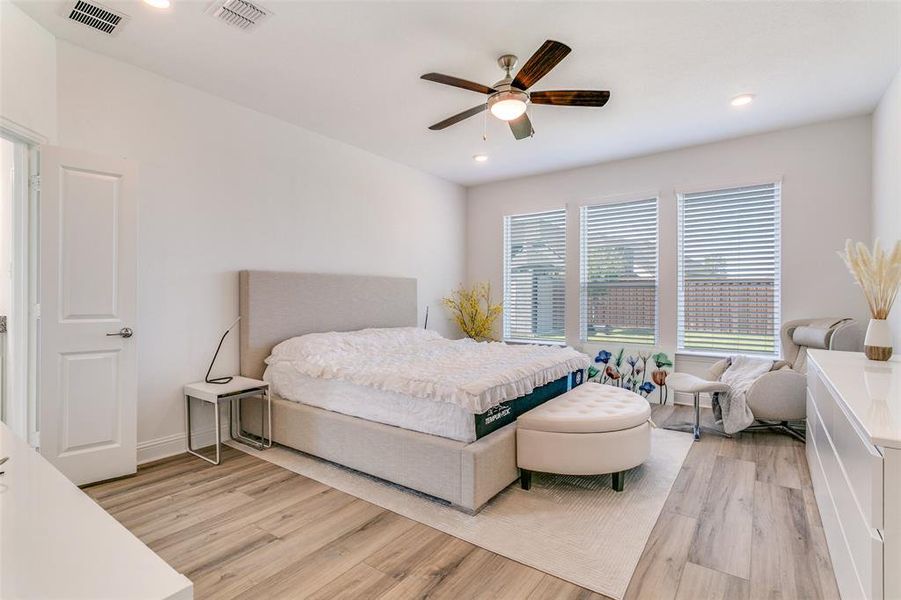 Bedroom featuring light wood finished floors, ceiling fan, and recessed lighting