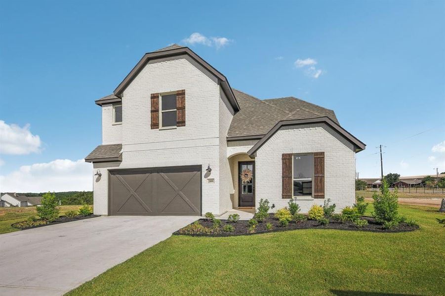 View of front of house with a garage and a front yard