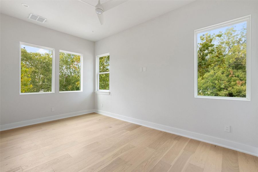 Unfurnished room featuring light wood-style flooring and ceiling fan Unfurnished room featuring light wood-style flooring and ceiling fan