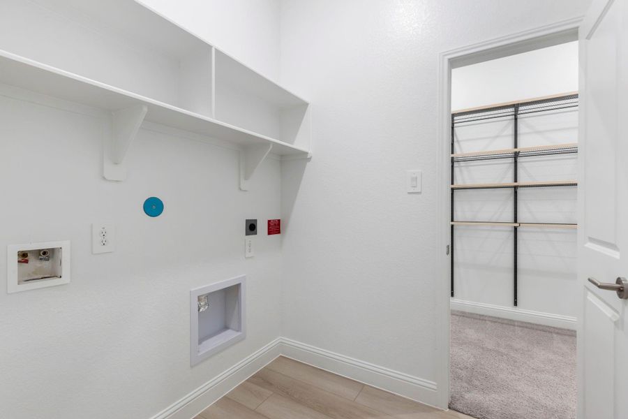 The primary closet conveniently connects to the utility room.