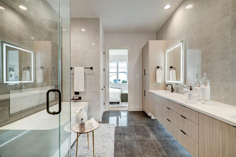 The staged model at Linear on Bell. Choose from two design packages and floor plans. With LED backlit mirrors, under vanity lighting, floor to ceiling tile work, and metal trimmed niches, this bathroom is perfectly inviting.