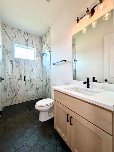 Modern bathroom featuring sleek vanity, stylish hexagon floor tiles, and a spacious walk-in shower. Modern bathroom featuring sleek vanity, stylish hexagon floor tiles, and a spacious walk-in shower.