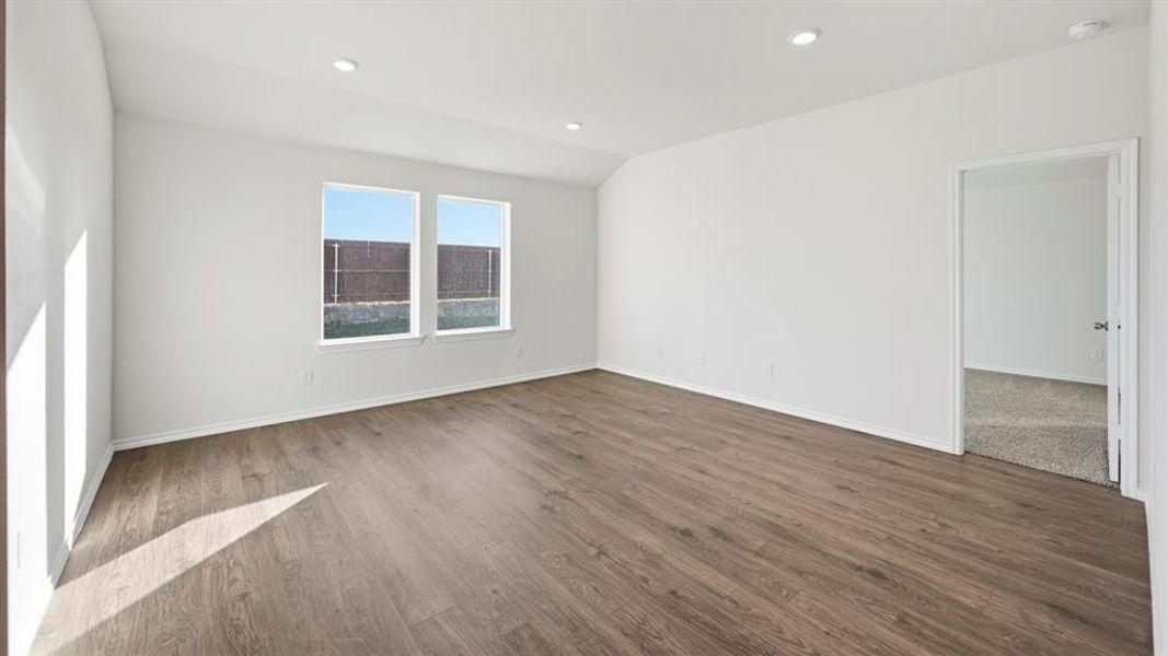 Empty room featuring dark wood-style floors, recessed lighting, and lofted ceiling Empty room featuring dark wood-style floors, recessed lighting, and lofted ceiling