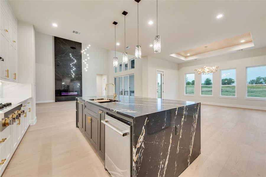 Kitchen with a sink, stainless steel appliances, open floor plan, a chandelier, and white cabinets Kitchen with a sink, stainless steel appliances, open floor plan, a chandelier, and white cabinets