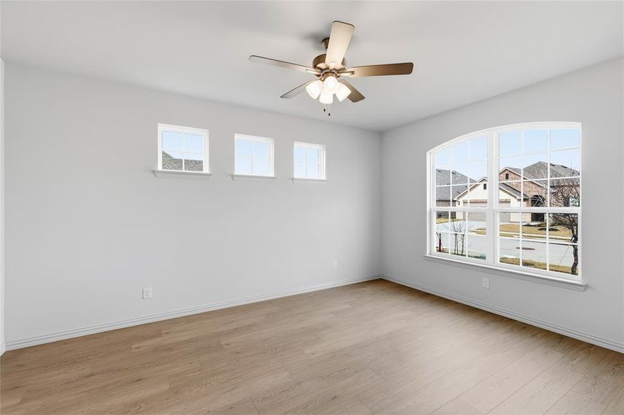 Empty room featuring a ceiling fan and light wood-style floors