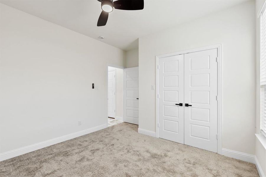 Unfurnished bedroom with a ceiling fan, a closet, baseboards, and carpet flooring Unfurnished bedroom with a ceiling fan, a closet, baseboards, and carpet flooring
