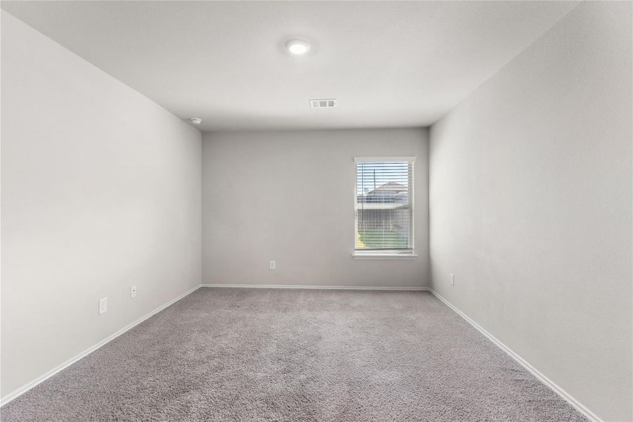 Primary bedroom with carpet flooring and backyard facing window. Primary bedroom with carpet flooring and backyard facing window.