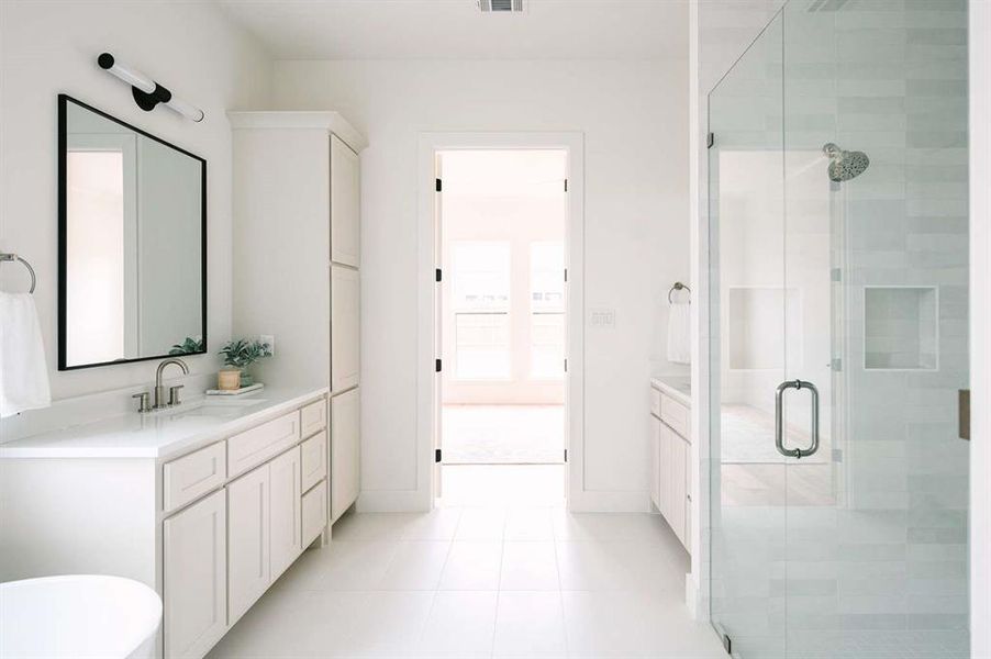 Bathroom featuring a shower with door, tile patterned floors, and vanity