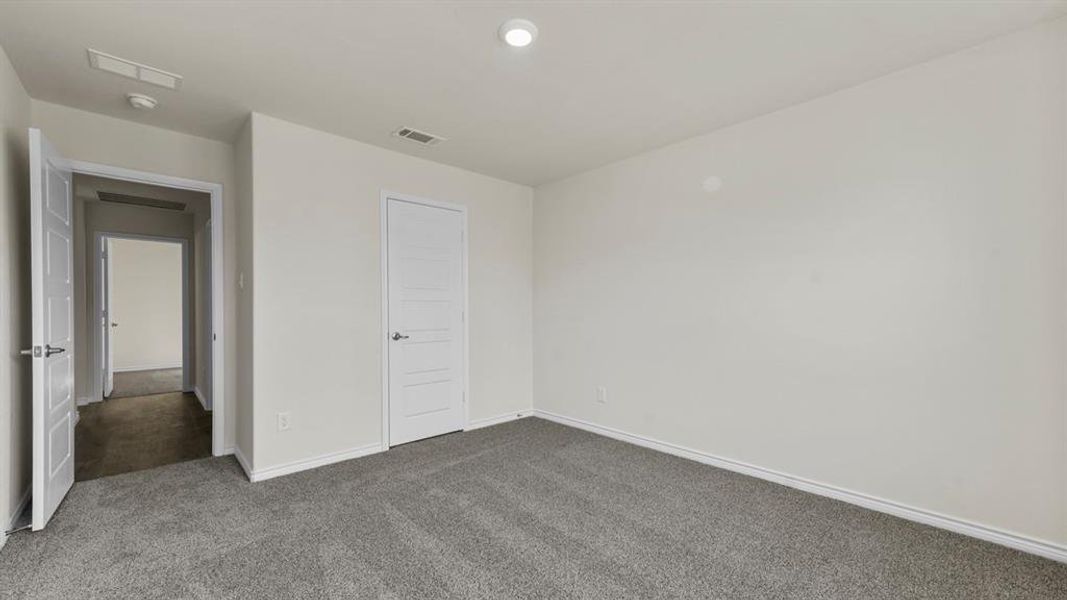 Carpeted interior room featuring light gray walls, white baseboards, and a recessed ceiling light
