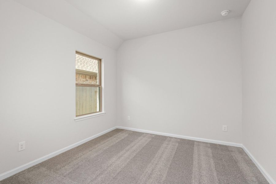 Additional secondary bedroom with neutral finishes and window, offering flexible space for guests or family.