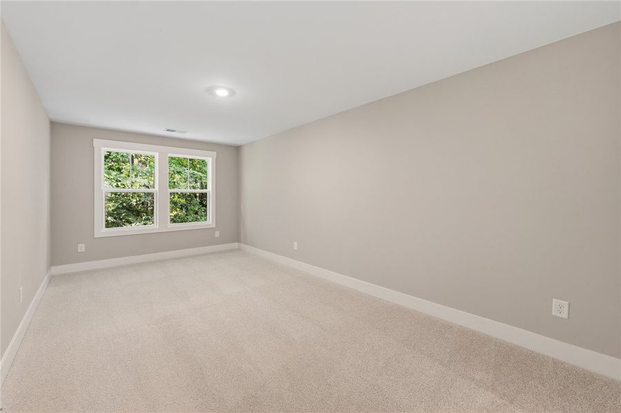 A spacious room with soft carpeting, illuminated b