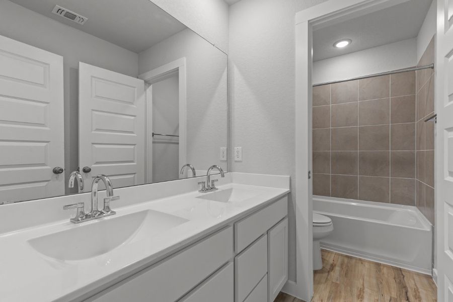 A bathroom with a tub sink and toilet.