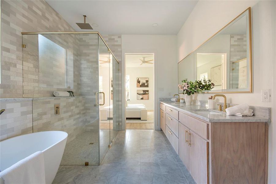 Bathroom featuring ensuite bathroom, double vanity, a soaking tub, a stall shower, and a ceiling fan Bathroom featuring ensuite bathroom, double vanity, a soaking tub, a stall shower, and a ceiling fan