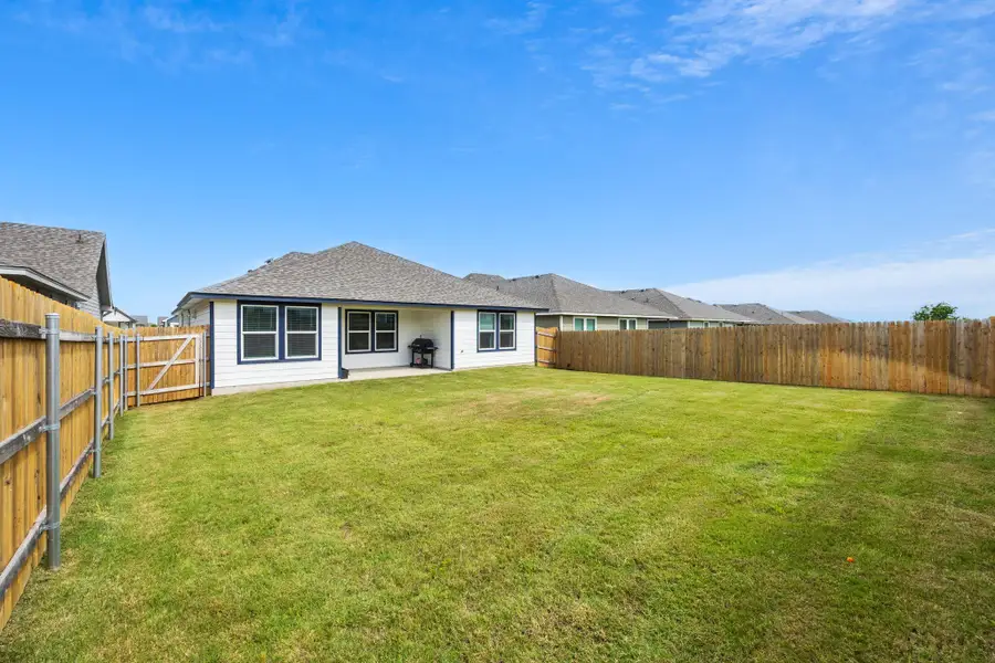 A spacious, enclosed backyard offers ample green space and a private setting.