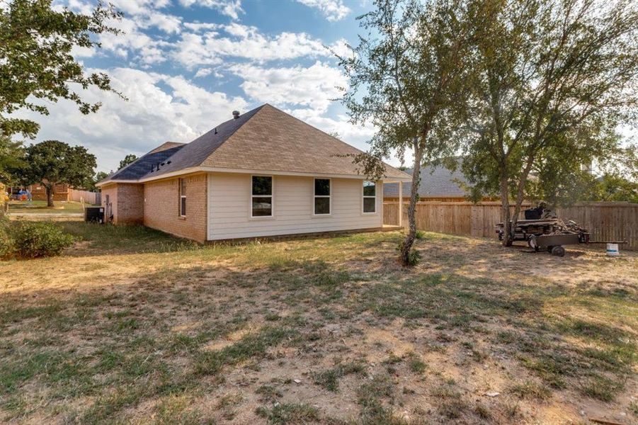Rear view of property with roof with shingles and brick siding