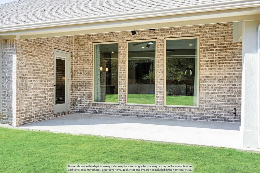 Brick home exterior with large sliding glass doors, concrete patio, and green lawn Brick home exterior with large sliding glass doors, concrete patio, and green lawn