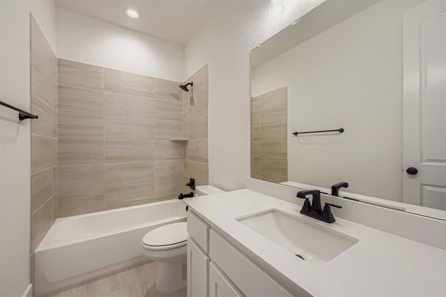 Bathroom featuring washtub / shower combination, vanity, and recessed lighting Bathroom featuring washtub / shower combination, vanity, and recessed lighting