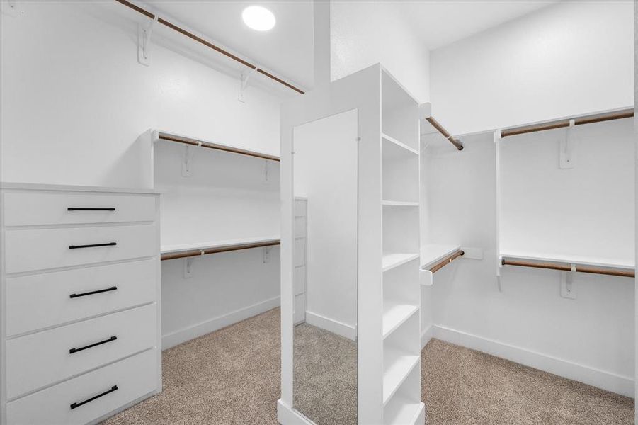 Primary closet enjoys cabinets and shelving