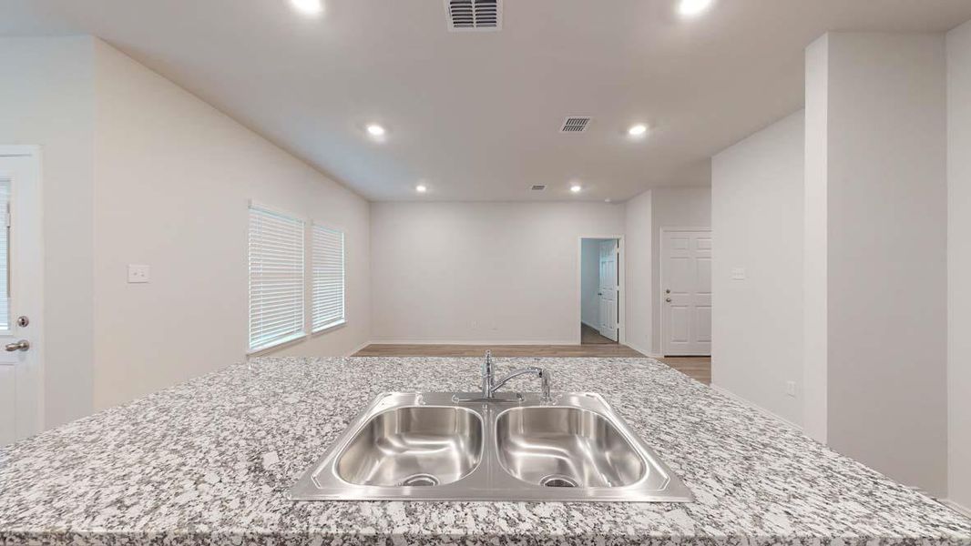 Granite countertop with integrated double basin stainless steel sink and modern chrome faucet
