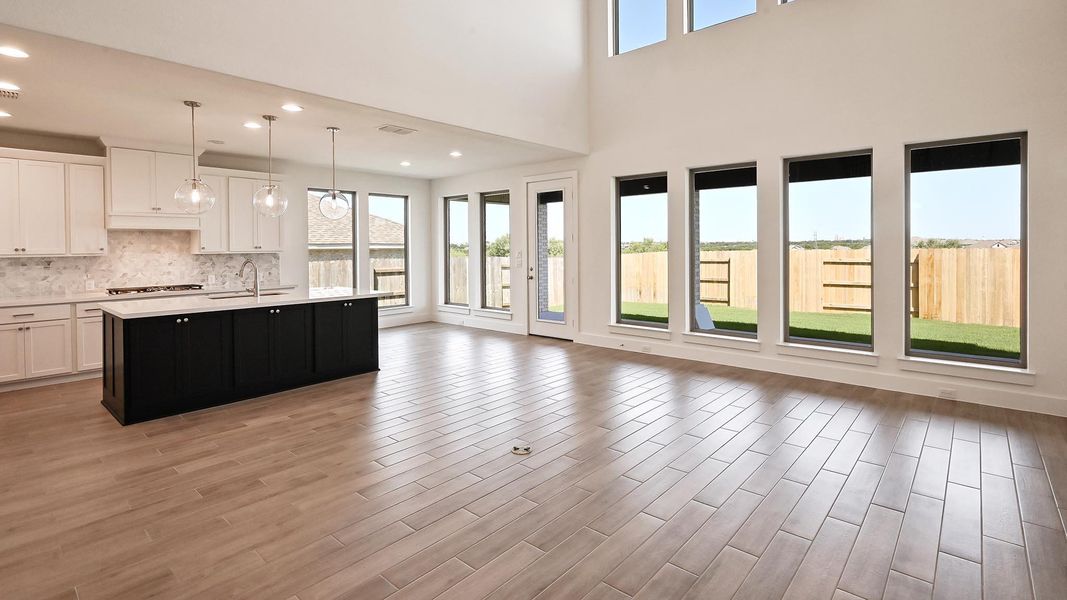 Kitchen featuring light countertops, plenty of natural light, decorative backsplash, white cabinetry, and recessed lighting