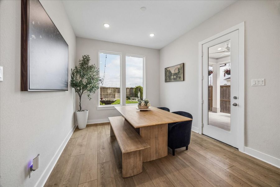 The dining area is filled with natural light from two large windows and offers easy access to the backyard, creating a bright and inviting space for everyday meals or gatherings.