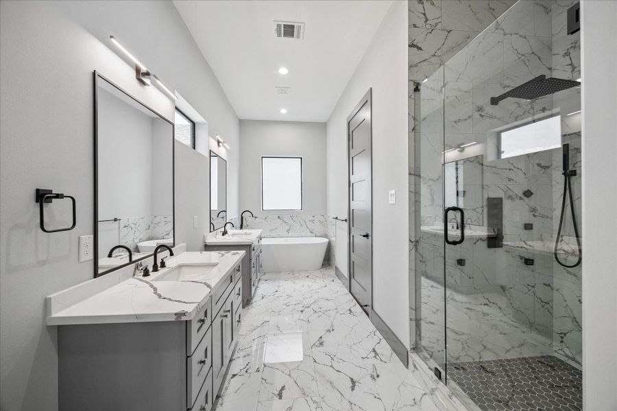 Designed with relaxation in mind, this bathroom features dual vanities, a freestanding soaking tub, and a spacious glass-enclosed shower. Modern fixtures balance style with functionality.