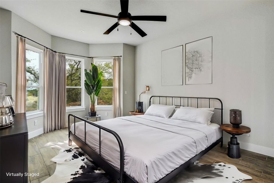 Bedroom with ceiling fan, light wood finished floors, and baseboards