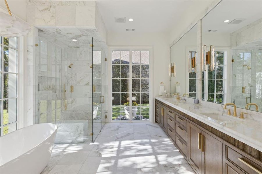 Bathroom with a freestanding tub, double vanity, a marble finish shower, healthy amount of natural light, and recessed lighting