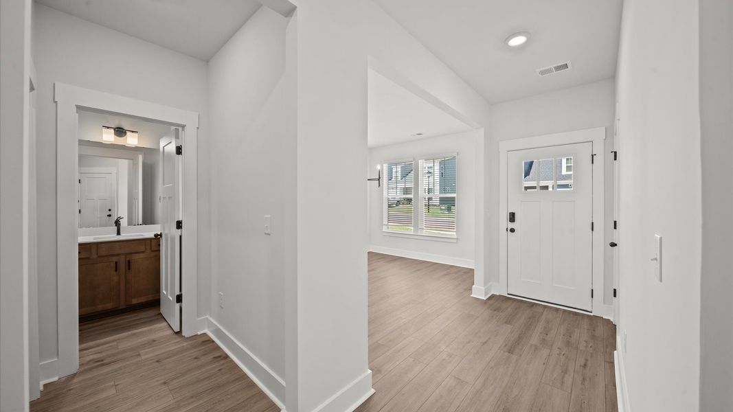Memorable arrival experience with hardwood floors and elegant trim in the foyer