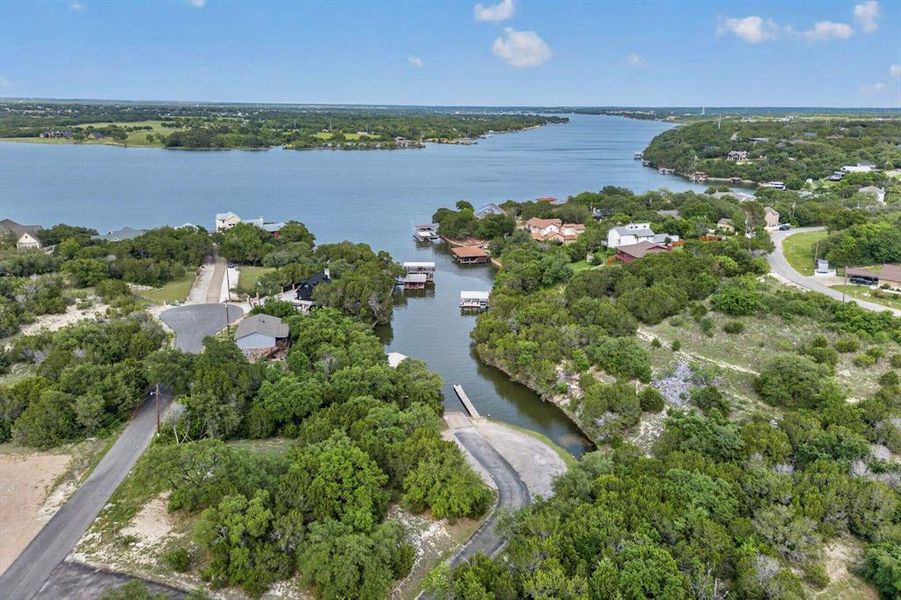 Extensive waterfront property featuring a private boat ramp, dock access, and natural landscaping with mature trees