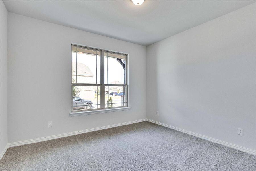 Carpeted spare room featuring baseboards Carpeted spare room featuring baseboards