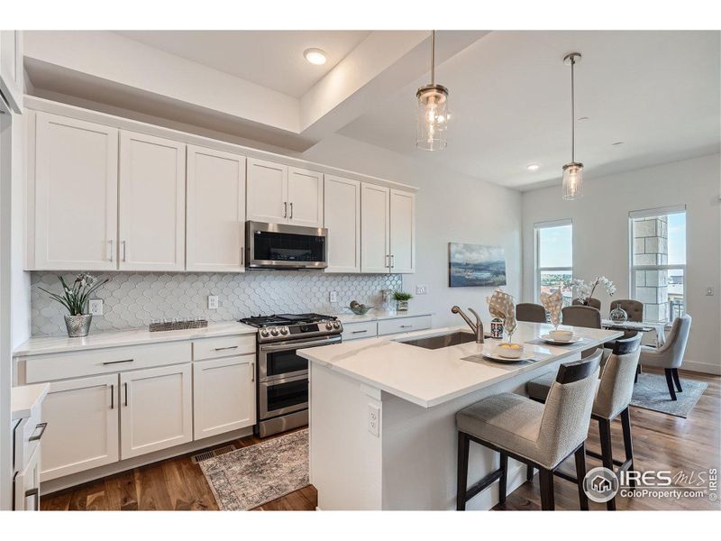 Perfect open plan kitchen with quartz countertops, brand new stainless steel appliances, gas range with double ovens.