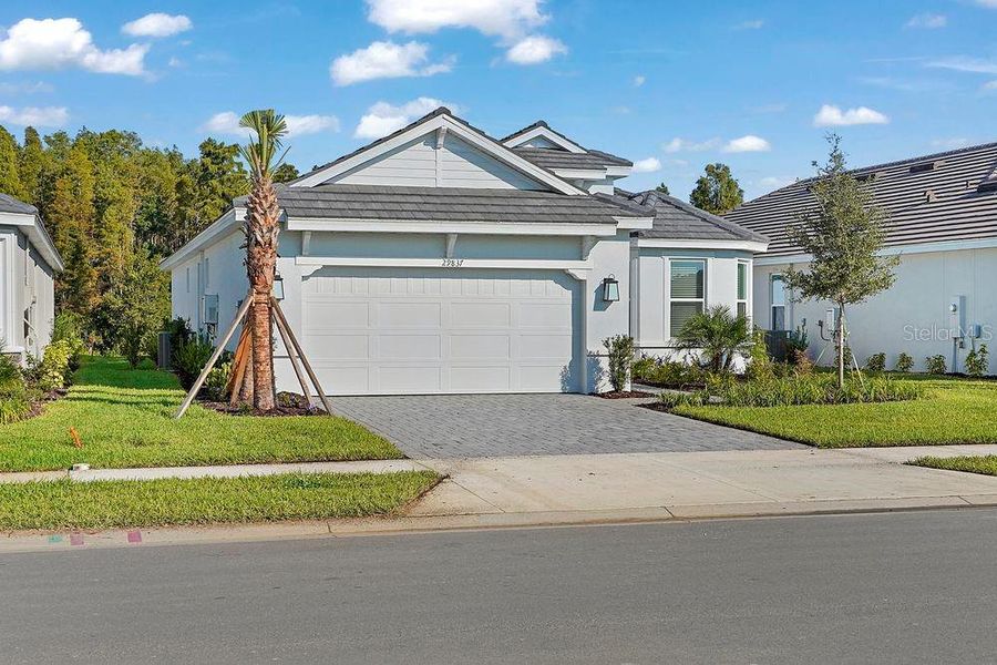 Front exterior of a new home in Esplanade at Wiregrass Ranch, Wesley Chapel, FL, highlighting curb appeal (Image 1).