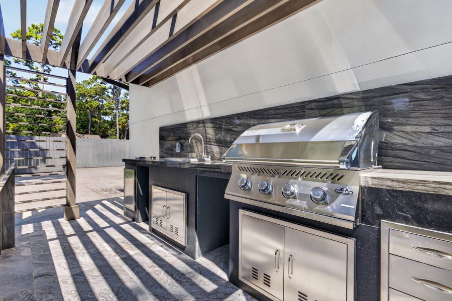 Fully equipped outdoor kitchen elevates entertaining with built-in grilling and preparation space.