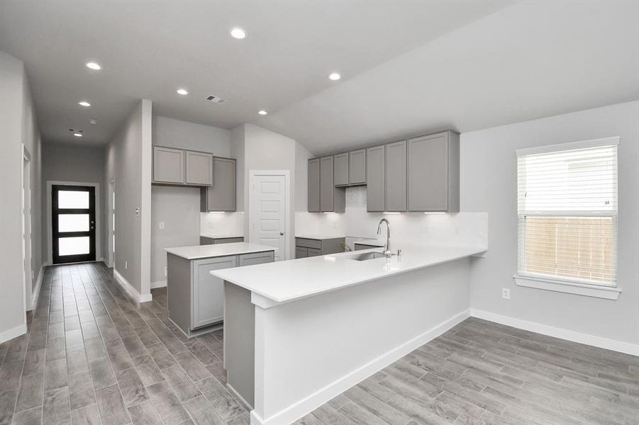 Discover another perspective of this stunning kitchen, generously appointed with an abundance of counter space. Sample photo of completed home. Actual color and selections may vary.