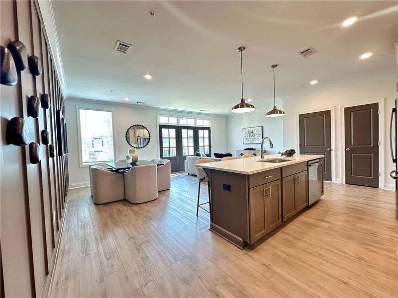 Open Concept Main Level Features Kitchen with 8 ft quartz Island with Dark island and Alabaster perimeter cabinetry & Modern Light wood flooring throughout. *Photos Showcase Warm Wheat Design Collection from a different Staged Model Home Site*
