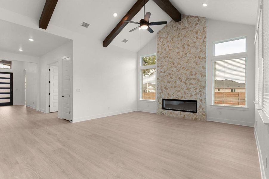 Unfurnished living room with a large fireplace, light wood finished floors, plenty of natural light, a ceiling fan, and recessed lighting