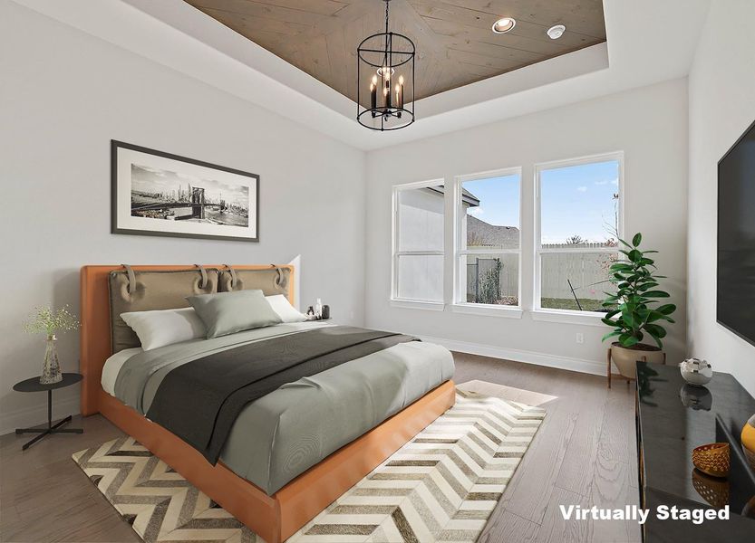Bedroom featuring a chandelier, baseboards, a raised ceiling, and wood finished floors Bedroom featuring a chandelier, baseboards, a raised ceiling, and wood finished floors
