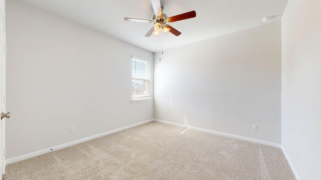 Empty room with light colored carpet and a ceiling fan