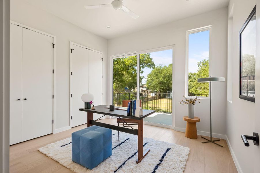 Sliding glass doors open to a private balcony, filling the workspace with natural light. Sliding glass doors open to a private balcony, filling the workspace with natural light.
