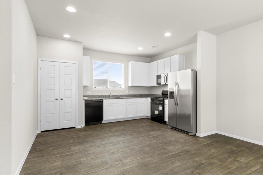 Kitchen featuring black appliances, white cabinets, dark wood-style flooring, and recessed lighting Kitchen featuring black appliances, white cabinets, dark wood-style flooring, and recessed lighting