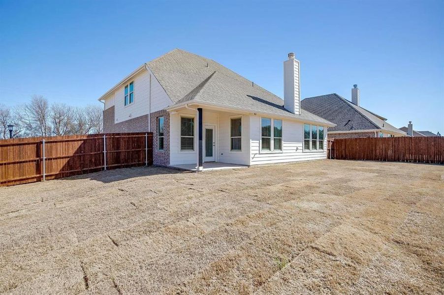 Back of property featuring a patio area and a lawn