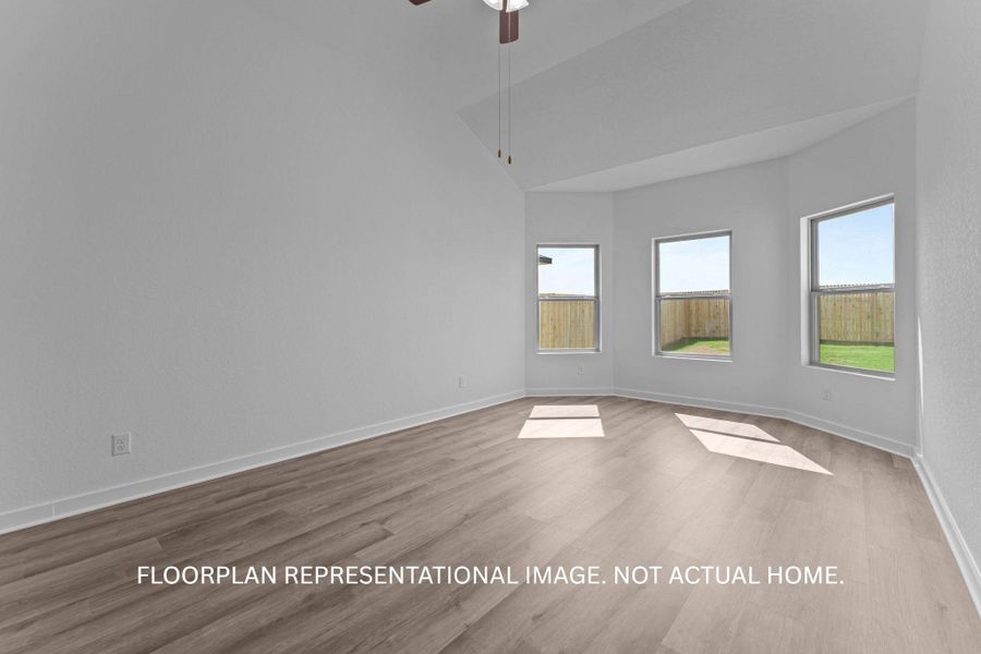 Sun-filled primary bedroom with vaulted ceilings and wide plank flooring offers a serene retreat.