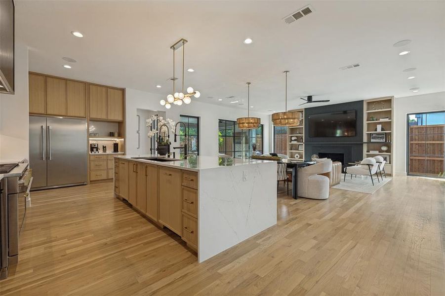 Open-concept kitchen and living area featuring wood-finish flooring Open-concept kitchen and living area featuring wood-finish flooring