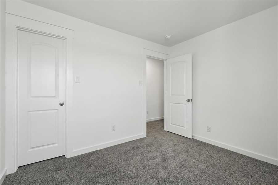Unfurnished bedroom with carpet floors and baseboards Unfurnished bedroom with carpet floors and baseboards