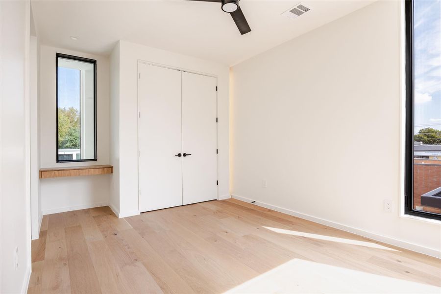 Unfurnished bedroom with light wood-style floors, a ceiling fan, and a closet